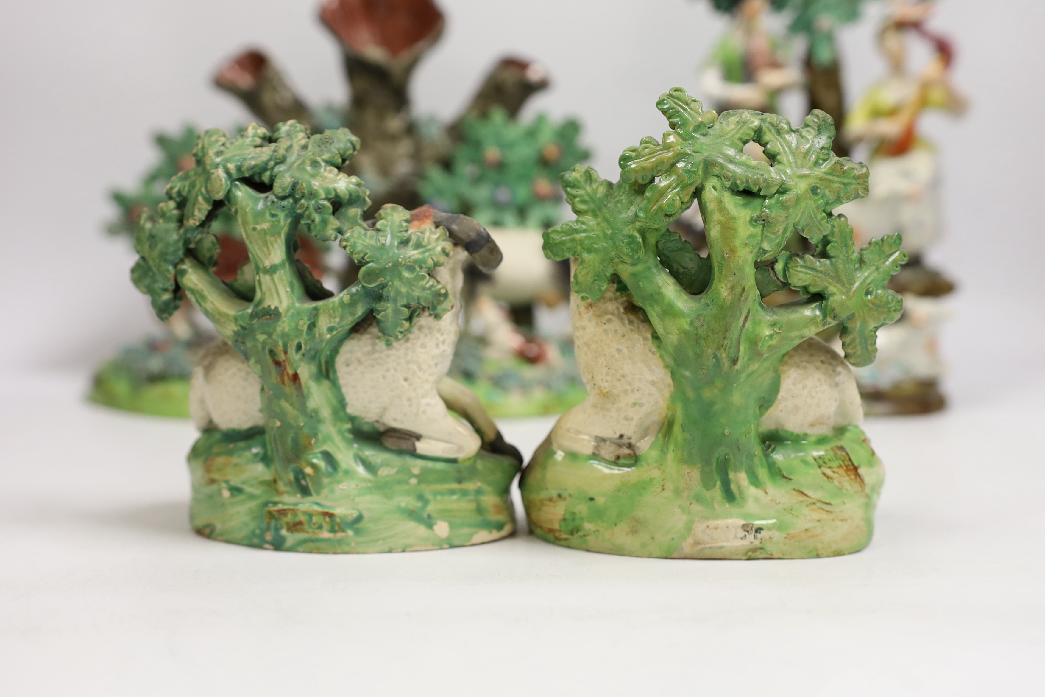 Four 19th century Staffordshire figurative groups; two musicians with sheep, etc. cows with calves group, and a pair of sheep and ram stamped ‘salt’, tallest 27cm